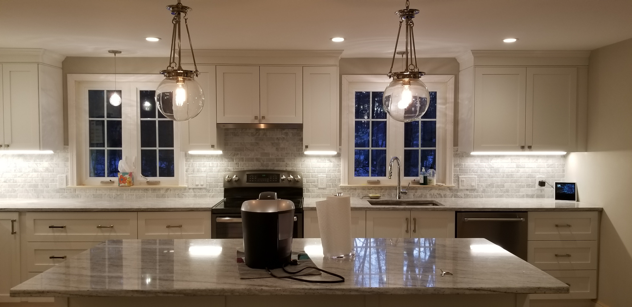 Finished kitchen with glass globe pendants and under-cabinet lights