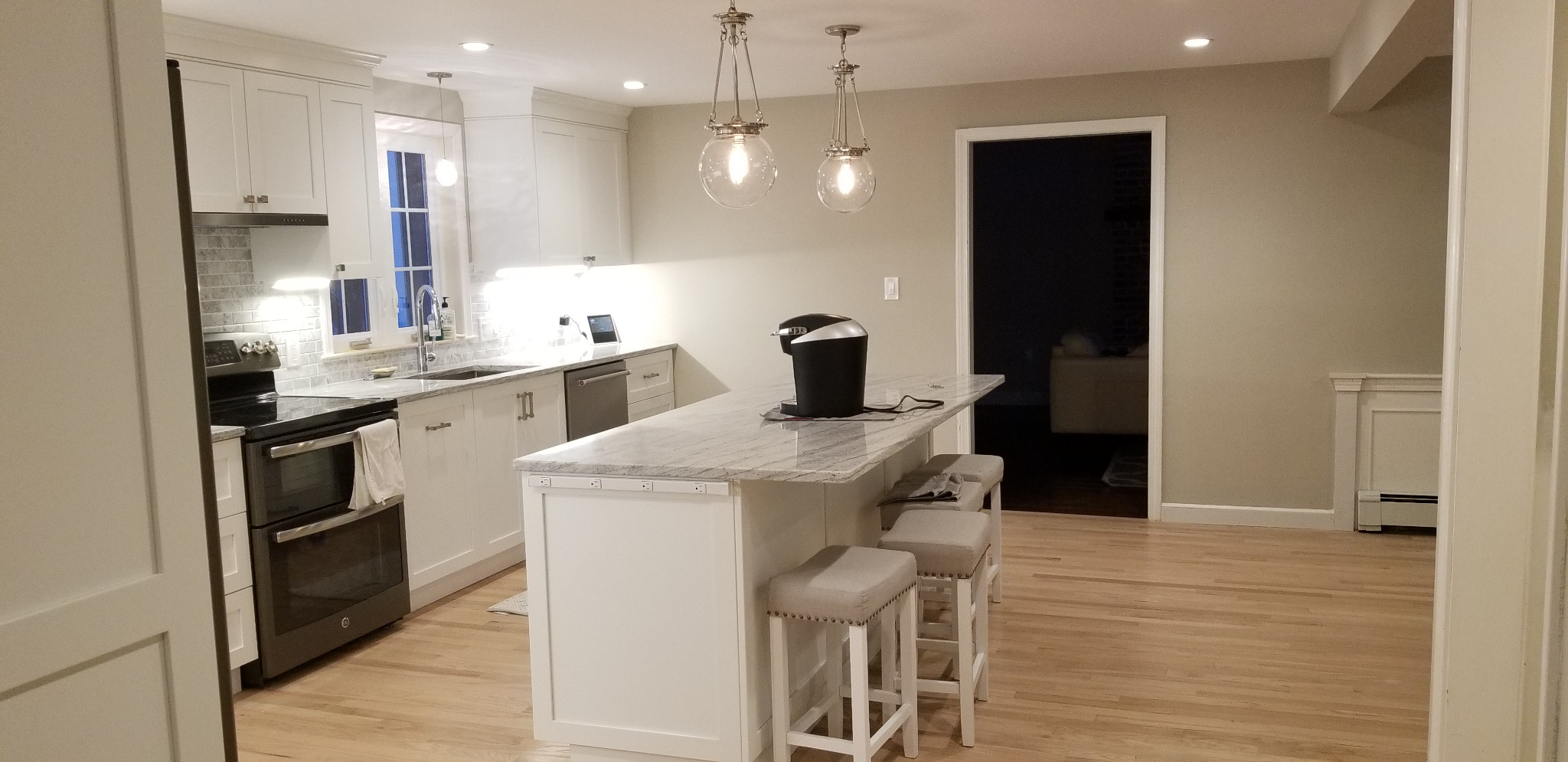 Kitchen island with glass pendant lights and electrical outlets
