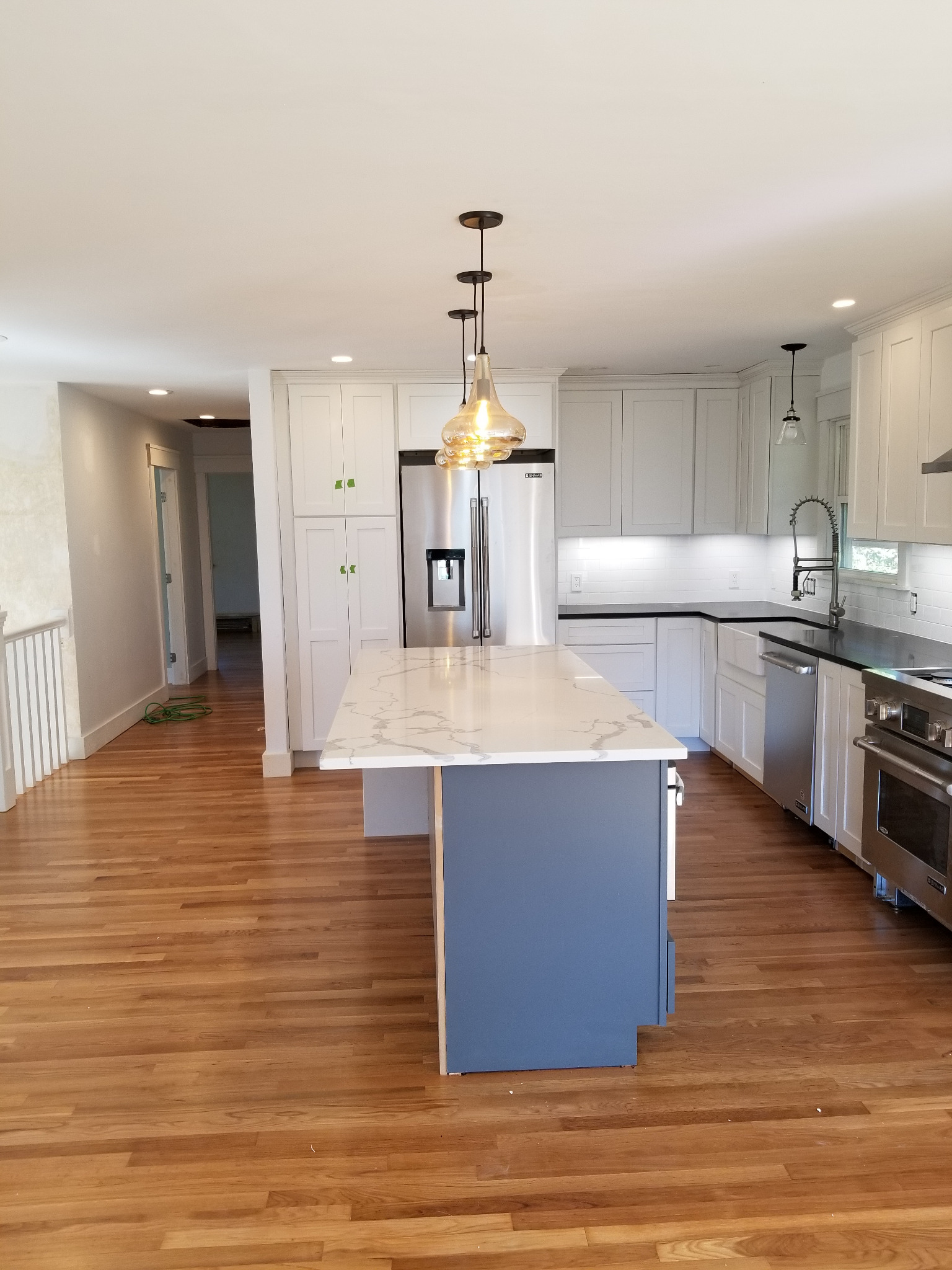 Kitchen island with pendant lighting and illuminated work areas