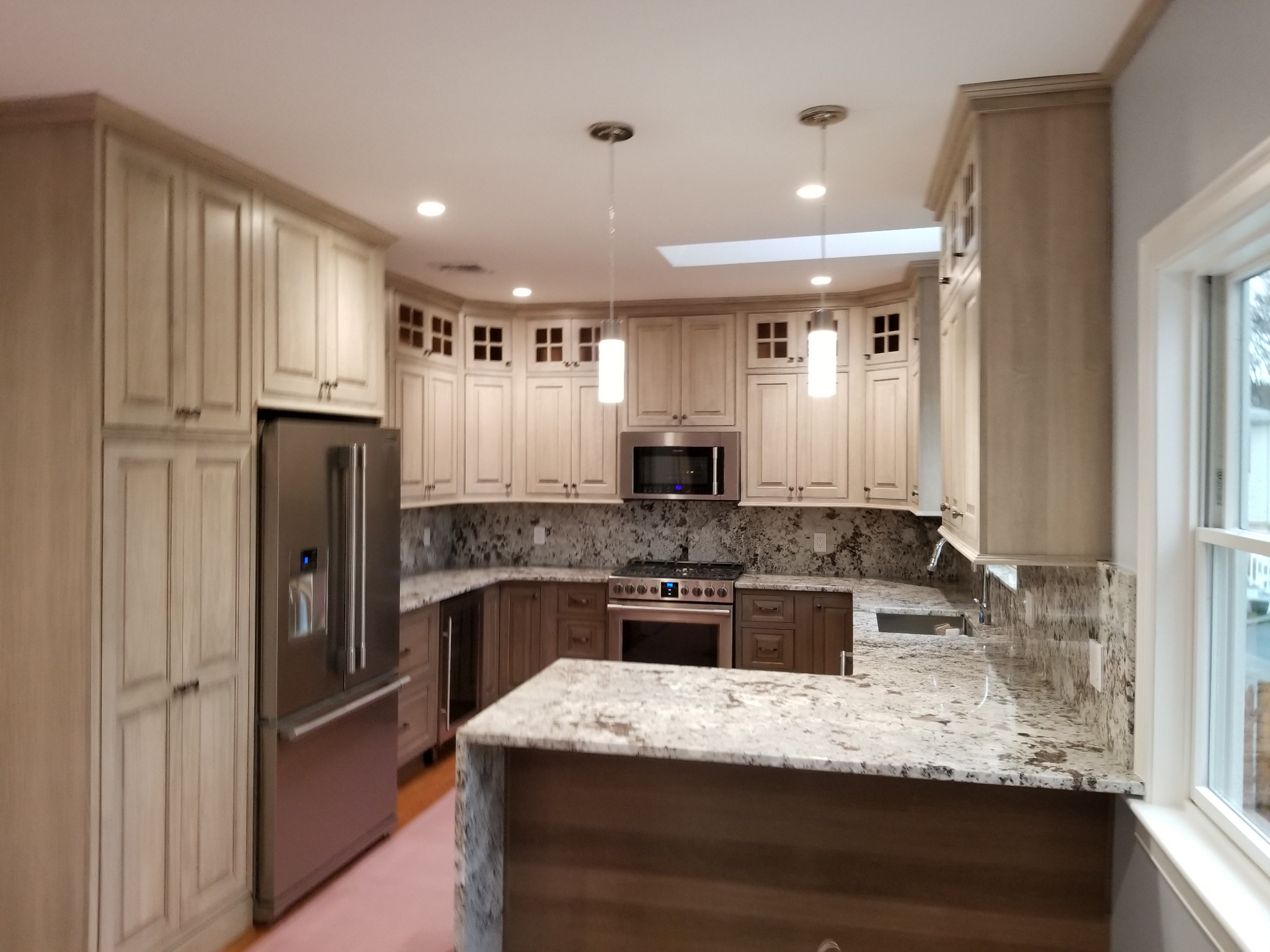 Kitchen renovation with overhead pendant and recessed lights
