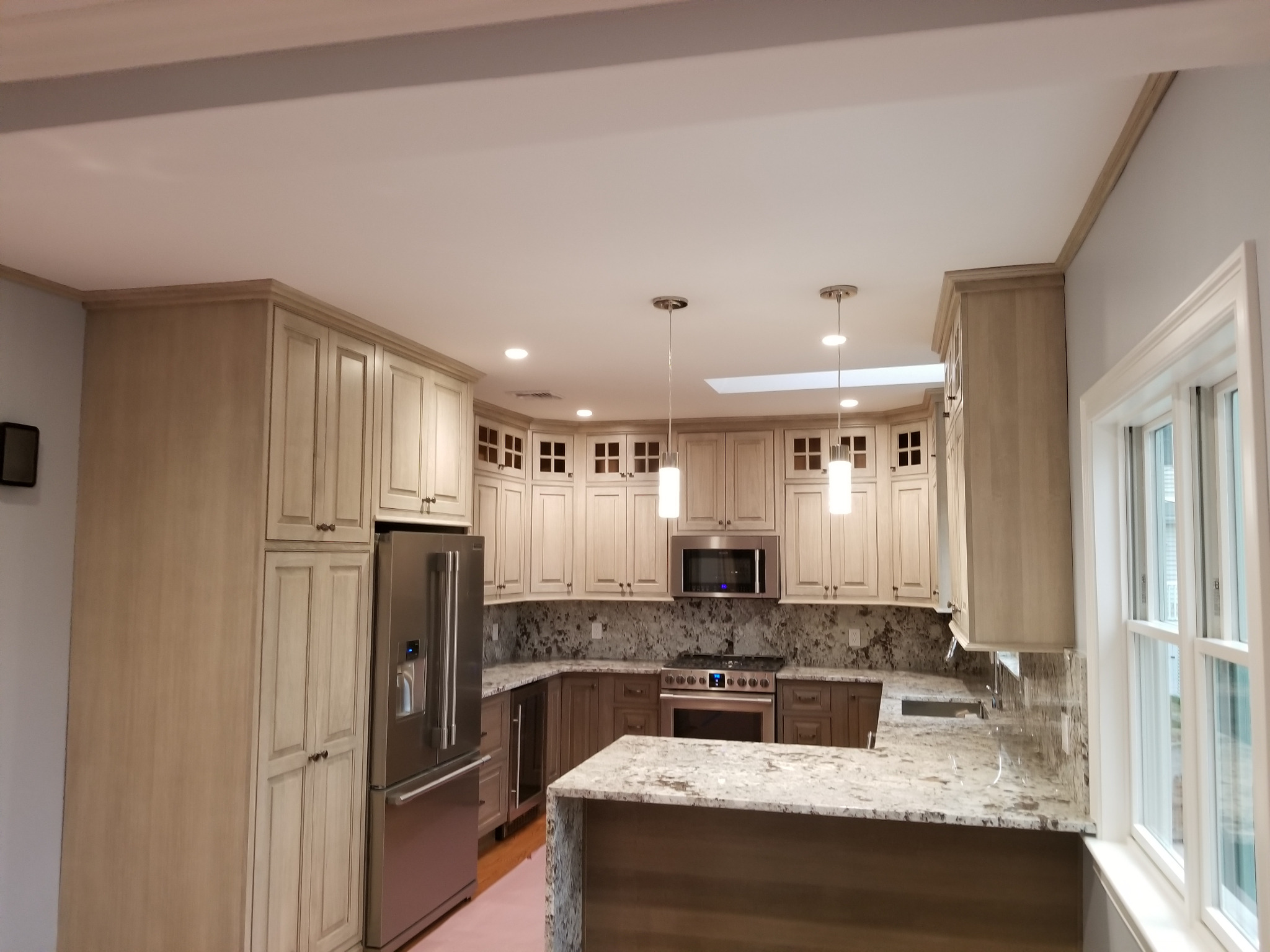 Wide kitchen with pendant and recessed ceiling lights