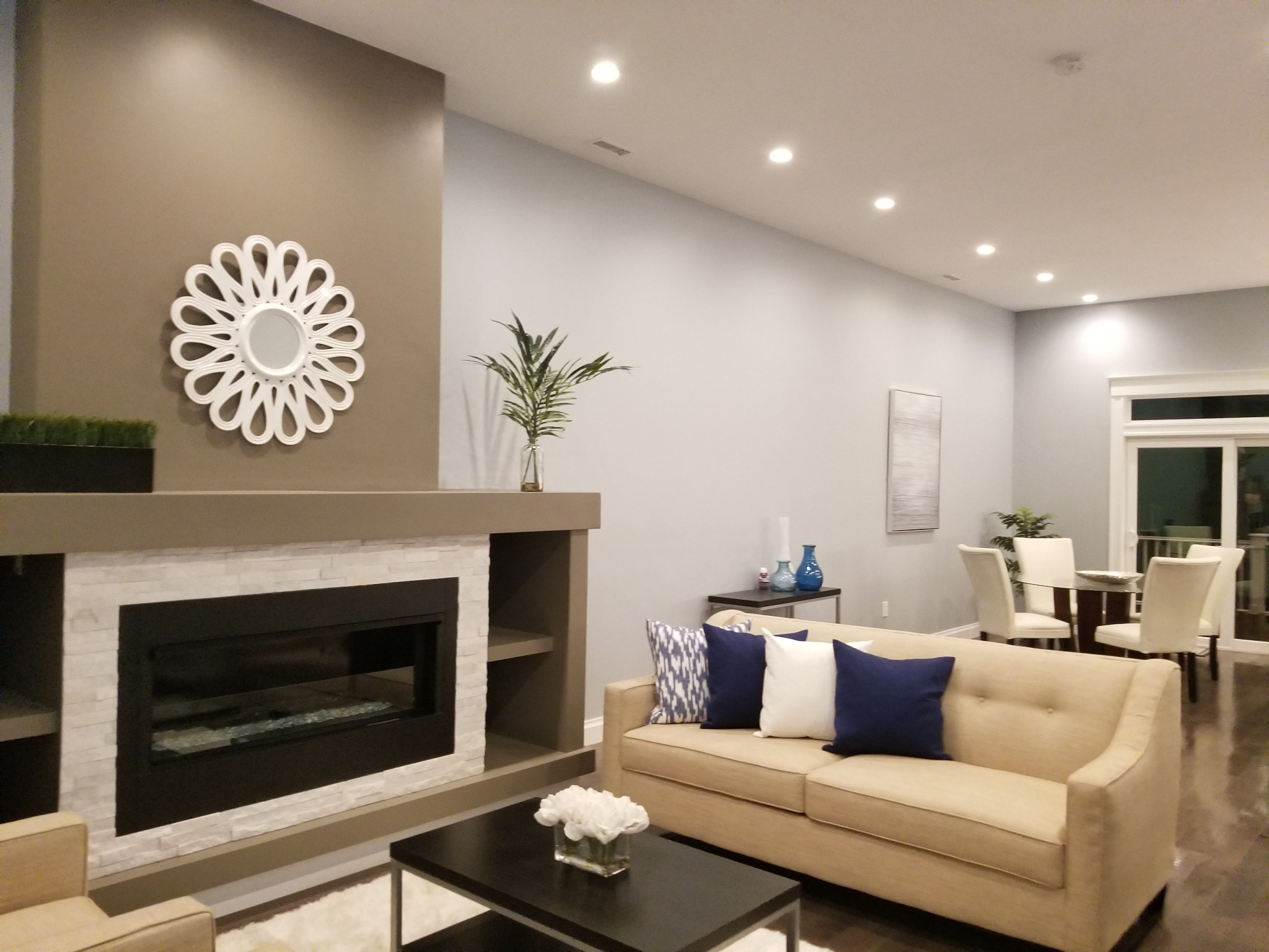 Living room with recessed ceiling lights and illuminated dining area